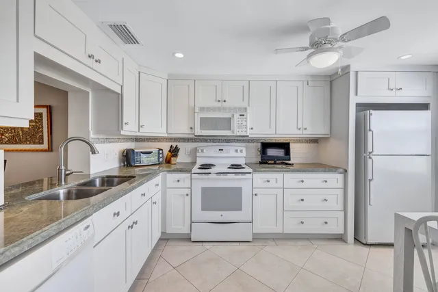 a kitchen with cabinets stainless steel appliances and a sink