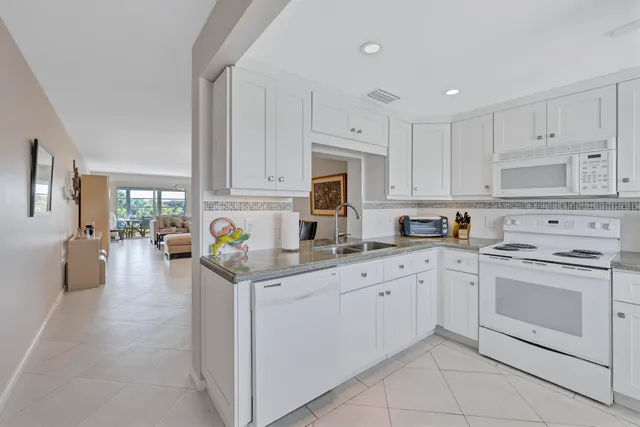 a kitchen with white cabinets and appliances