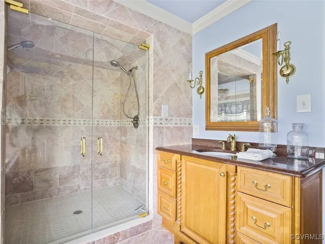 a bathroom with a granite countertop sink a mirror and a shower