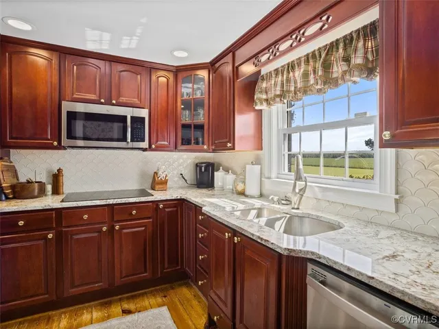 a kitchen with stainless steel appliances granite countertop a sink stove and cabinets