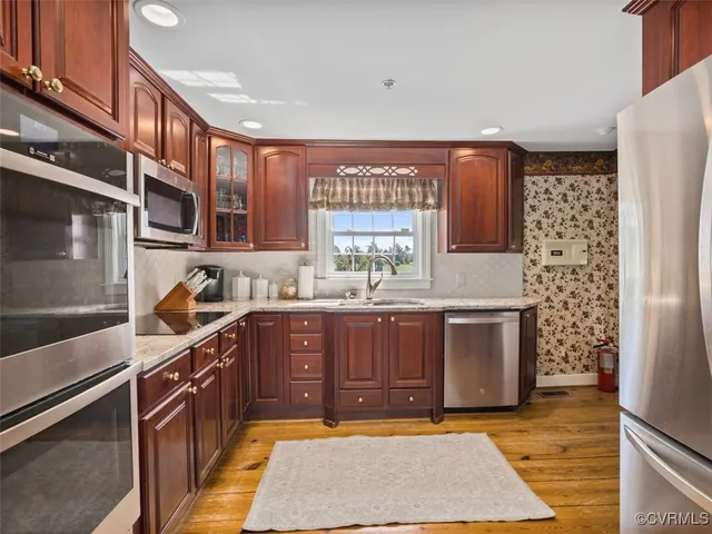 a kitchen with stainless steel appliances granite countertop a stove a sink and a refrigerator