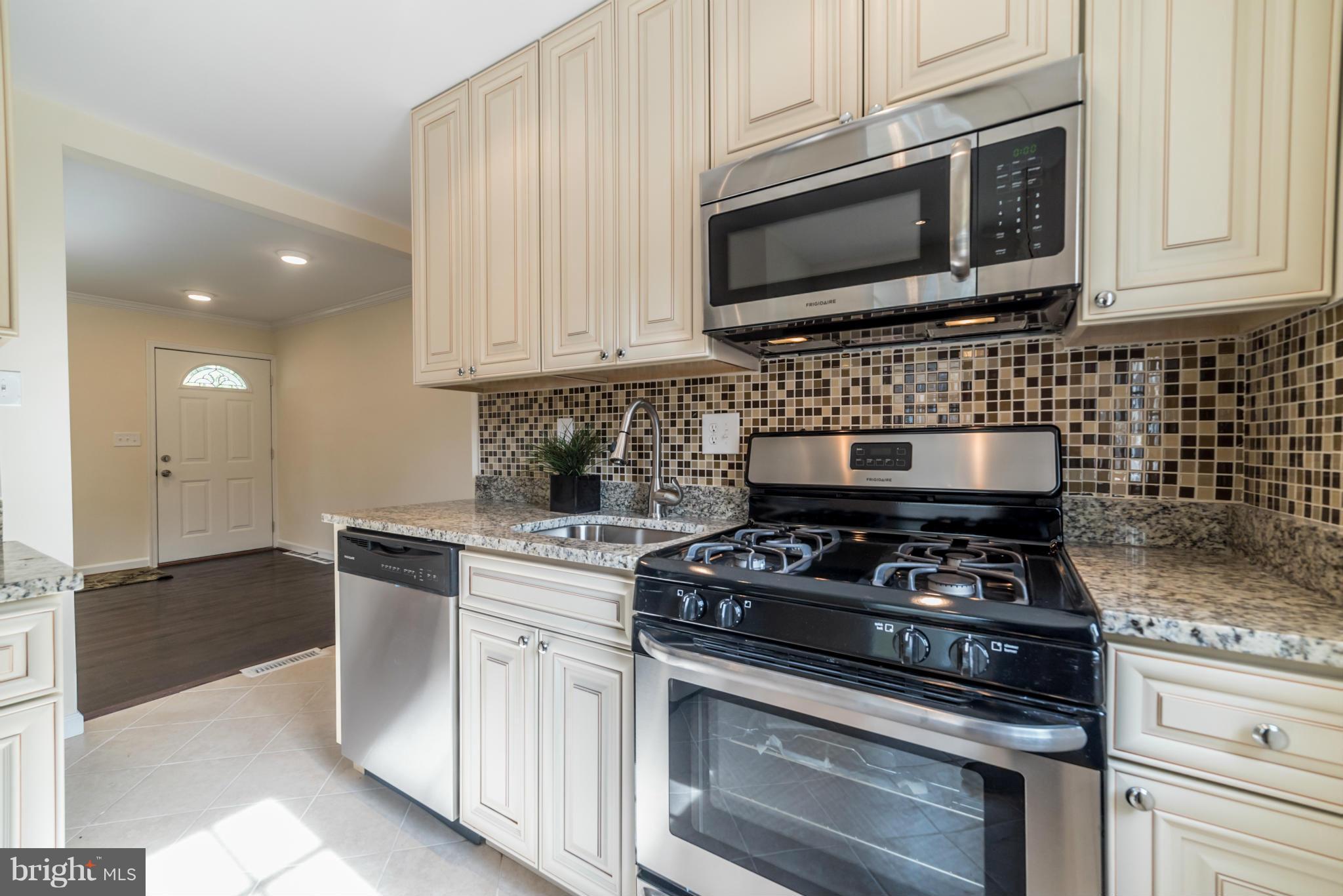 4106 Sampson Road Silver Spring, MD 20906 - Photo 6 of 30 a kitchen with stove a microwave and cabinets