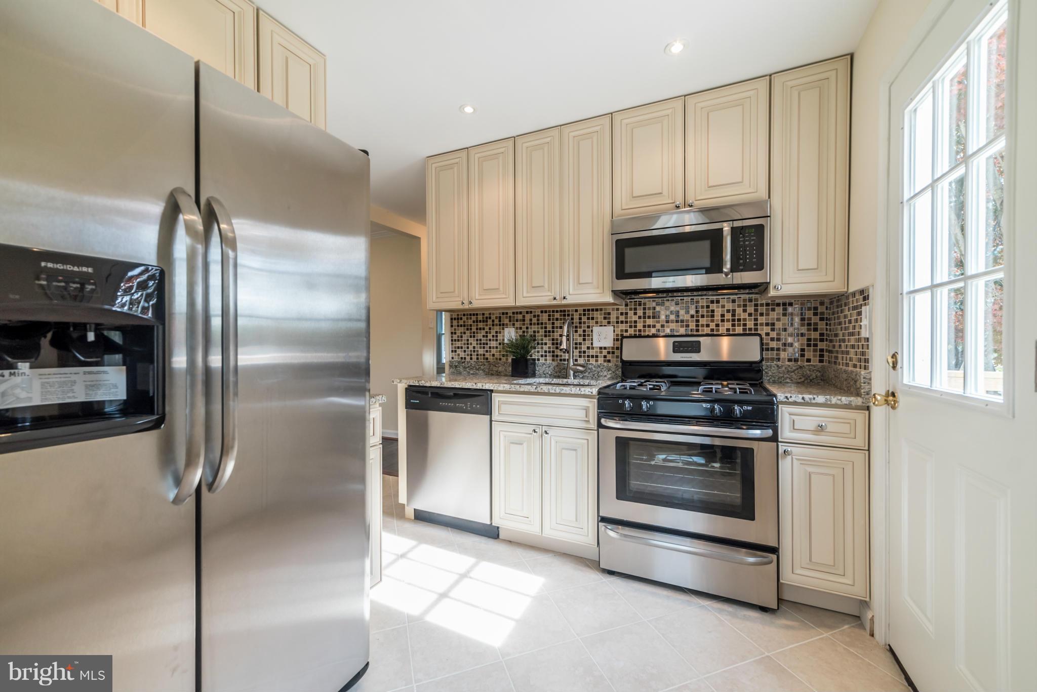 4106 Sampson Road Silver Spring, MD 20906 - Photo 8 of 30 a kitchen with stainless steel appliances granite countertop a stove a refrigerator and a microwave