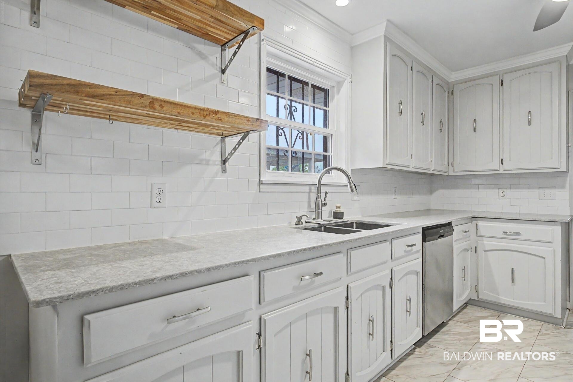 3791 Robinsonville Road Atmore, AL 36502 - Photo 25 of 47 Kitchen featuring white subway tile backsplash, light-toned countertops, and ample white cabinetry