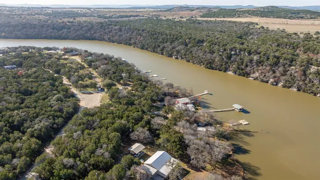 an aerial view of a house with a yard and lake view