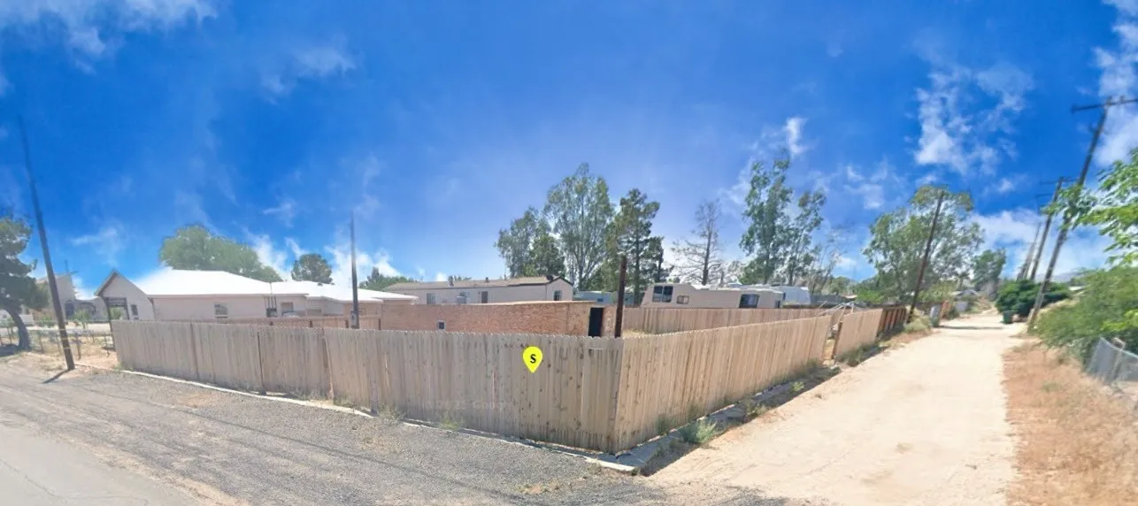 a view of a backyard with wooden fence