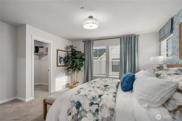 a bedroom with a bed and a large window