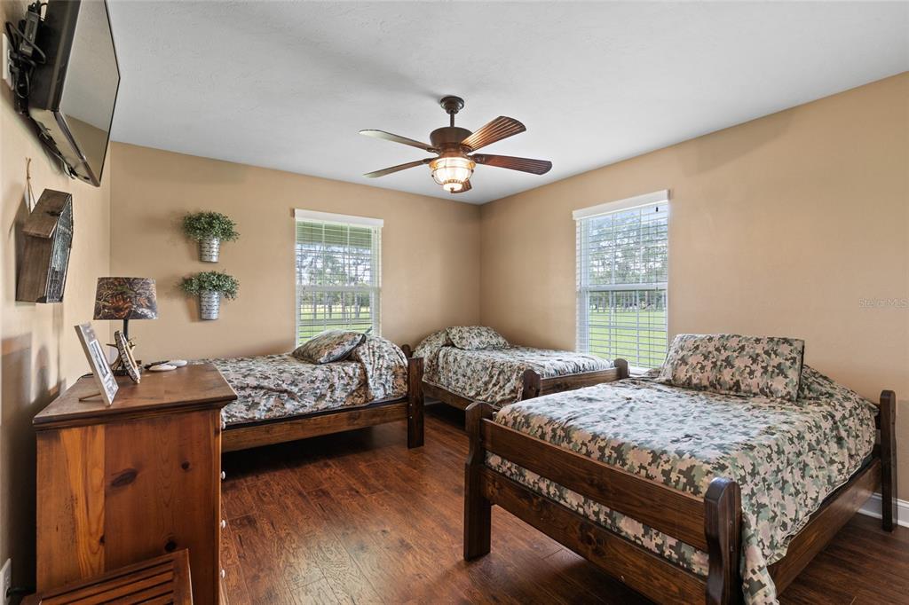 4639 Southwest Wilson Springs Road Fort White, FL 32038 - Photo 13 of 36 a bedroom with two beds and a chandelier