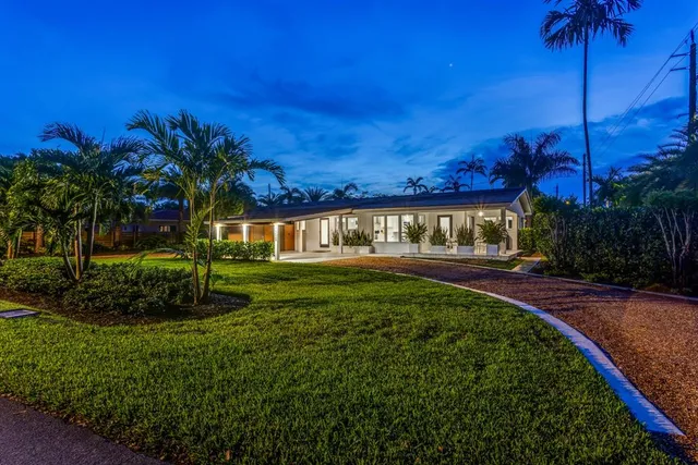 a view of a patio with a dining table and chairs with couches potted plants and a table
