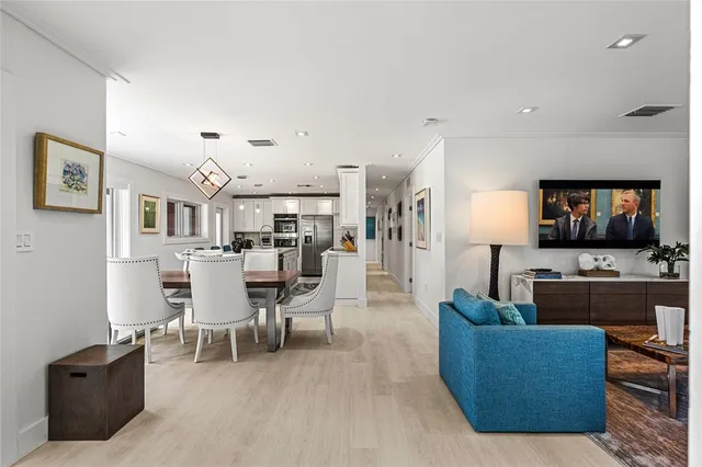 a living room with furniture kitchen view and a flat screen tv