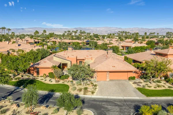 a view of house with swimming pool and a yard