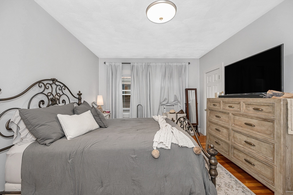 499 Humphrey Street, Unit 3 Swampscott, MA 01907 - Photo 11 of 27 a bedroom with a bed and a flat screen tv