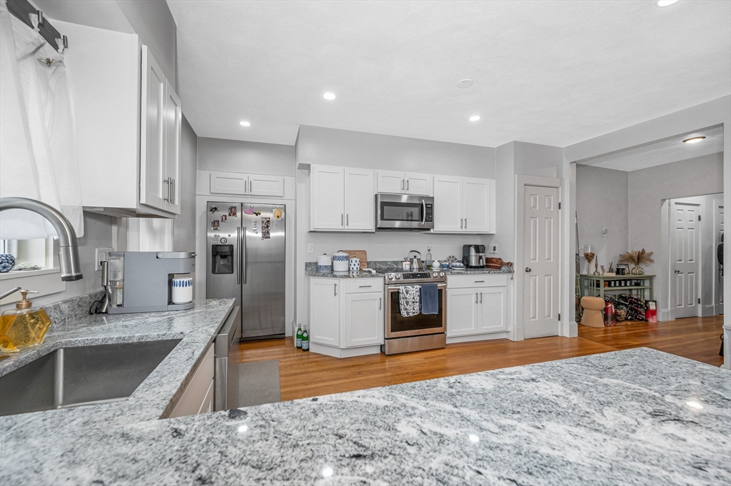499 Humphrey Street, Unit 3 Swampscott, MA 01907 - Photo 17 of 27 a kitchen with stainless steel appliances granite countertop a sink stove and refrigerator