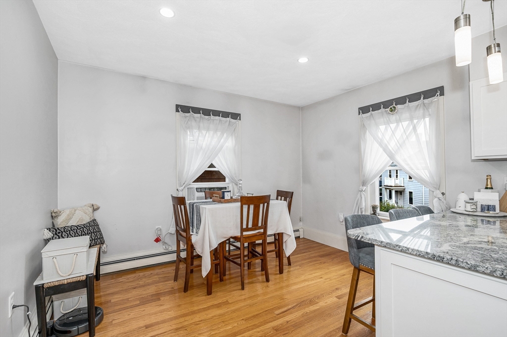 499 Humphrey Street, Unit 3 Swampscott, MA 01907 - Photo 19 of 27 a kitchen with granite countertop sink dining table and chairs