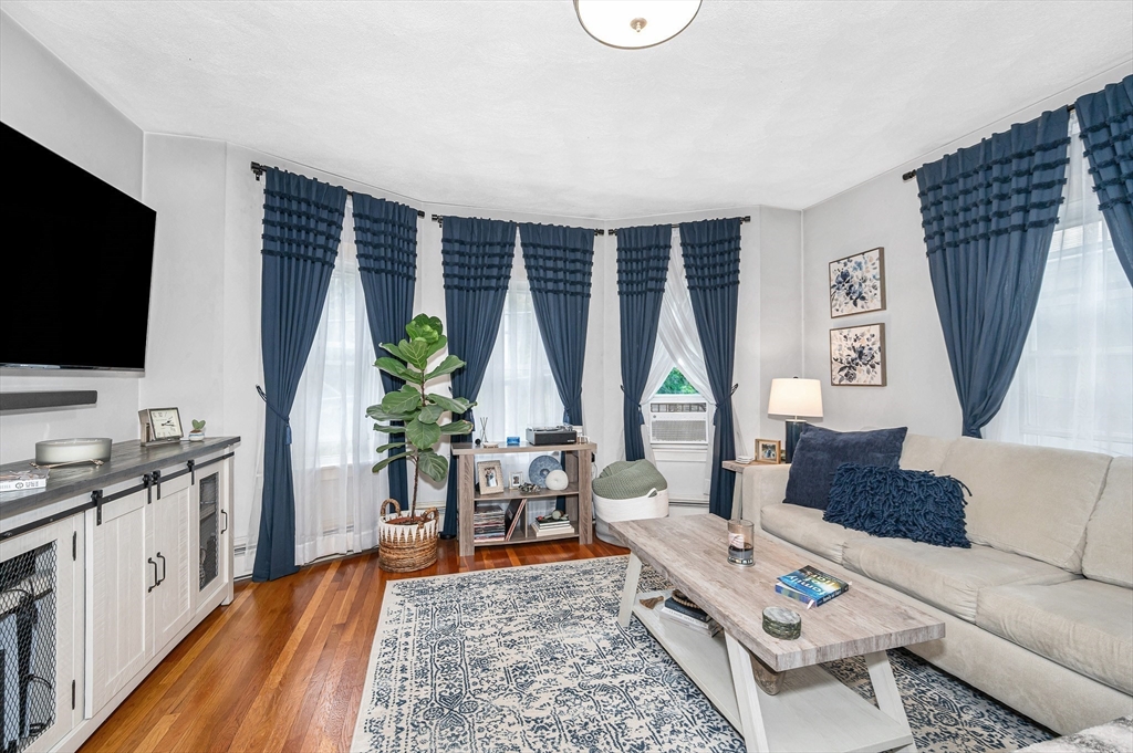 499 Humphrey Street, Unit 3 Swampscott, MA 01907 - Photo 4 of 27 a living room with furniture a flat screen tv and a large window