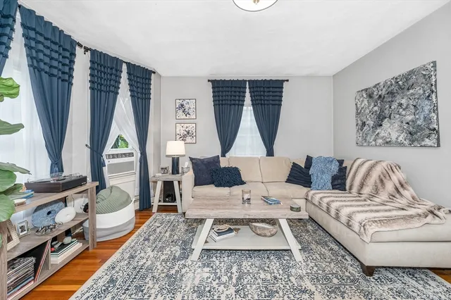 a living room with furniture a fireplace and a large window