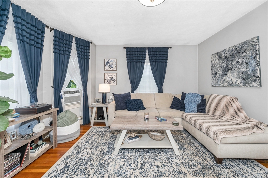 499 Humphrey Street, Unit 3 Swampscott, MA 01907 - Photo 7 of 27 a living room with furniture a fireplace and a large window