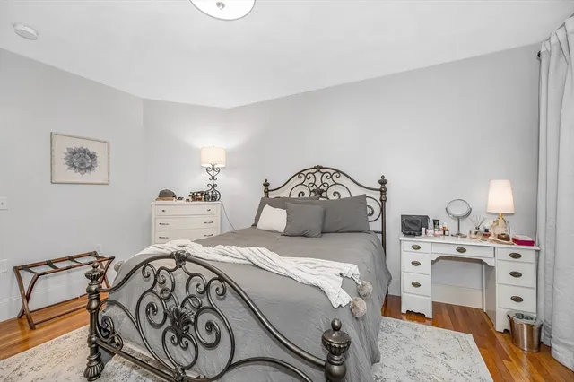 a bedroom with a bed and a lamp on dresser