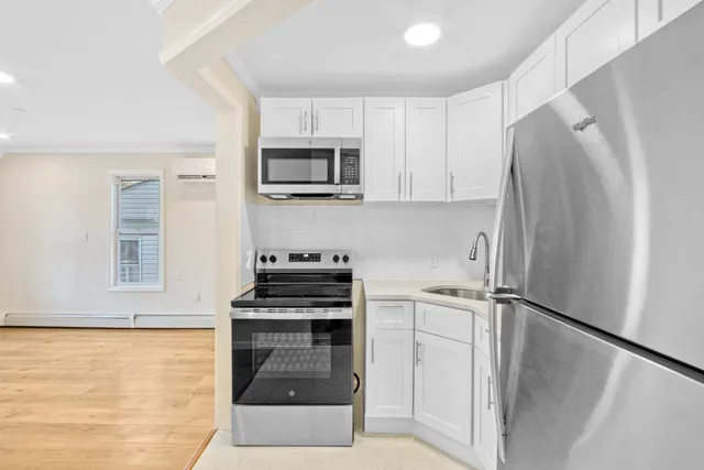 a kitchen with white cabinets and stainless steel appliances