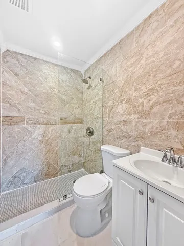 a bathroom with a sink a toilet and shower