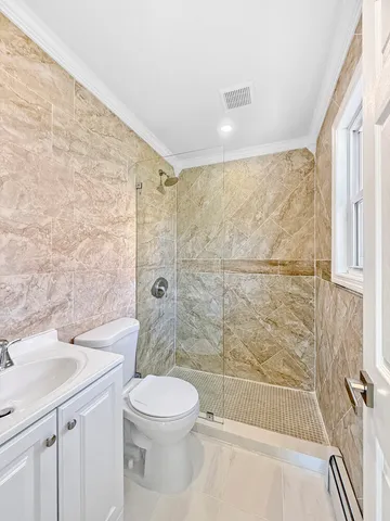 a bathroom with a bathtub shower sink vanity and toilet