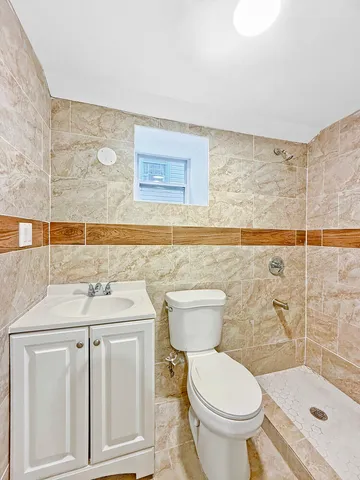 a bathroom with a granite countertop toilet and a sink