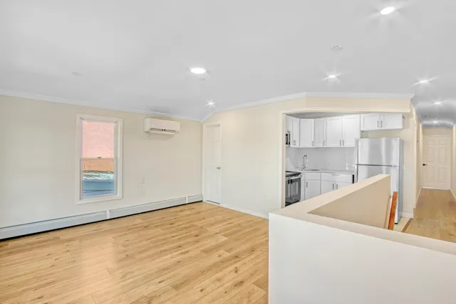 a view of a kitchen with a sink and dishwasher with wooden floor