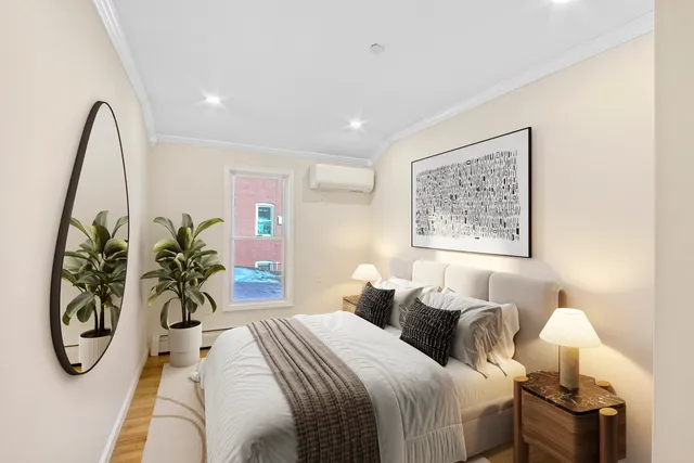 a bedroom with bed and a potted plant