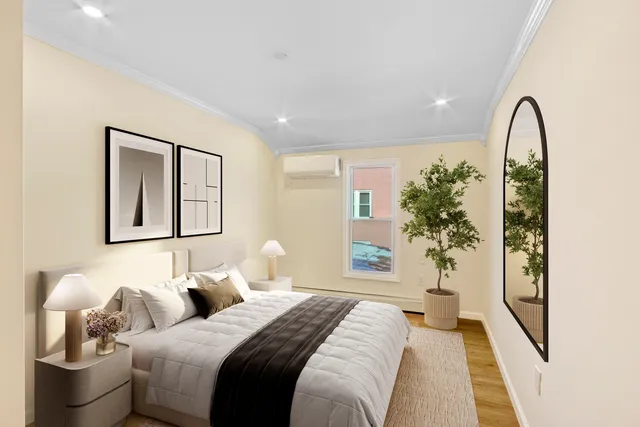 a bedroom with bed and a potted plant