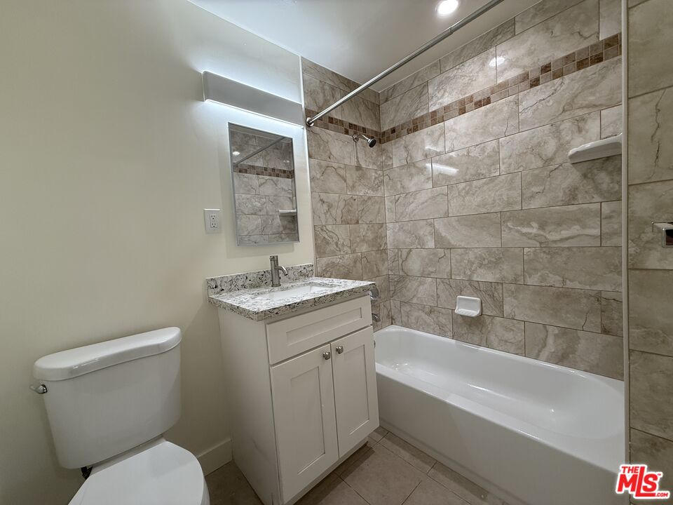 2400 Vanderbilt Lane, Unit 2402D Redondo Beach, CA 90278 - Photo 33 of 34 a bathroom with a granite countertop toilet a sink and bathtub