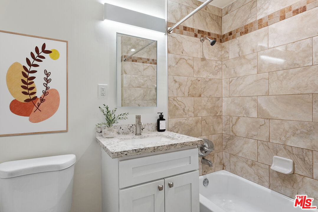 2400 Vanderbilt Lane, Unit 2402D Redondo Beach, CA 90278 - Photo 4 of 34 a bathroom with a granite countertop sink a toilet and a mirror
