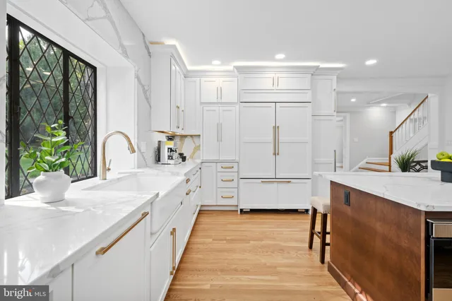 a kitchen with a sink white cabinets and counter space
