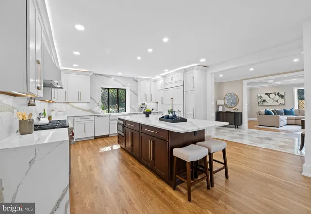 a kitchen with a dining table chairs stove and white cabinets