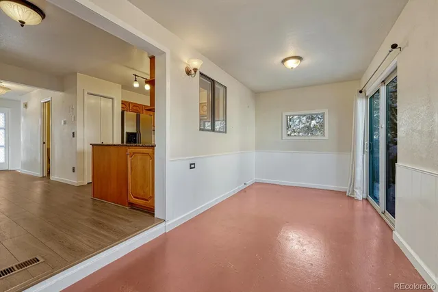 a view of a hallway with wooden floor and cabinet