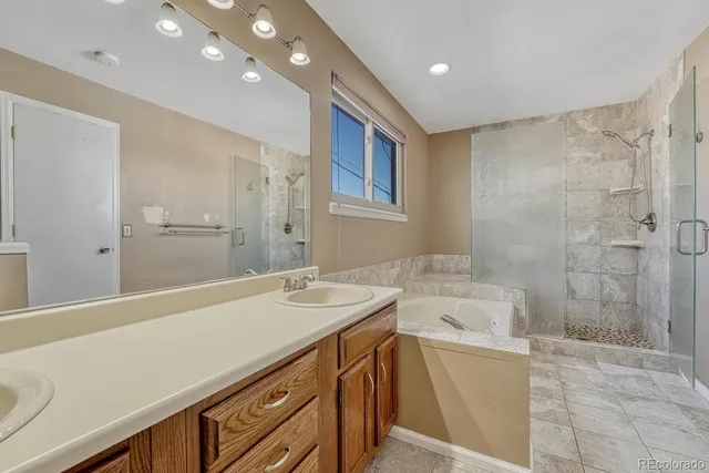 a bathroom with a sink a large mirror and a shower