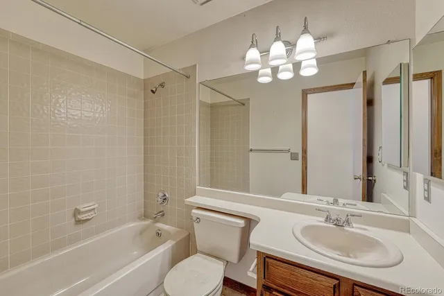 a bathroom with a sink a toilet a mirror a bathtub and shower