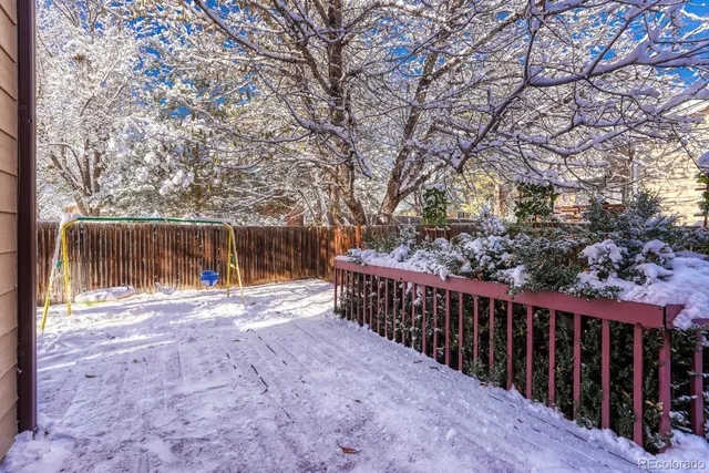 a view of backyard with wooden fence and trees