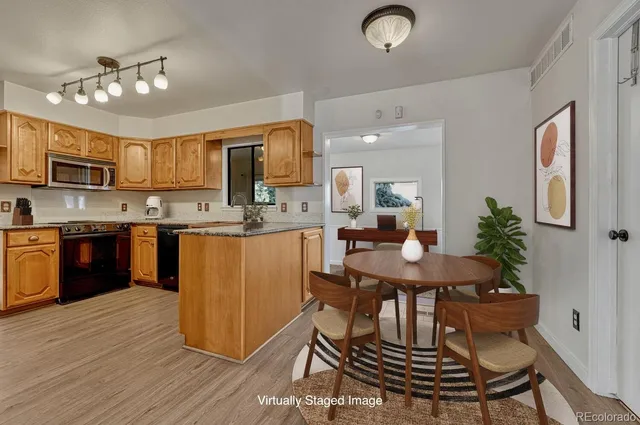 a kitchen with kitchen island a dining table and chairs