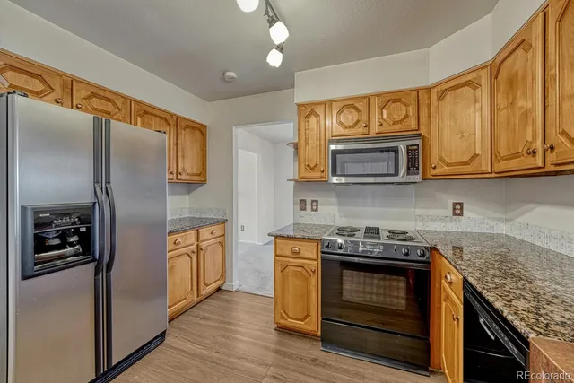 a kitchen with stainless steel appliances granite countertop a stove and a refrigerator