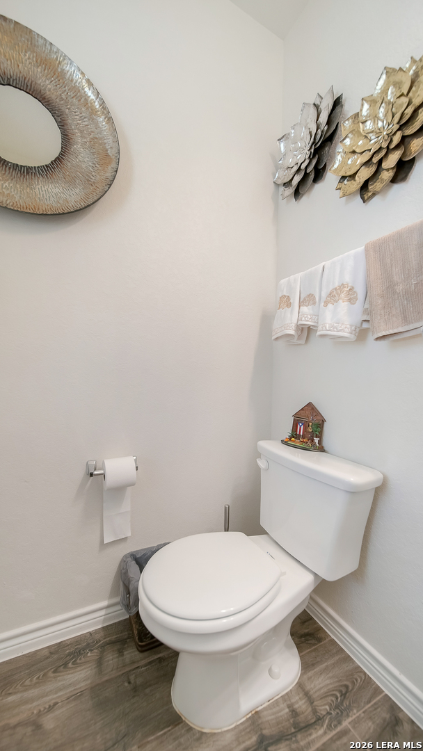 350 Colonial Bluff Universal City, TX 78148 - Photo 5 of 27 a white toilet sitting next to a bathroom sink and vanity