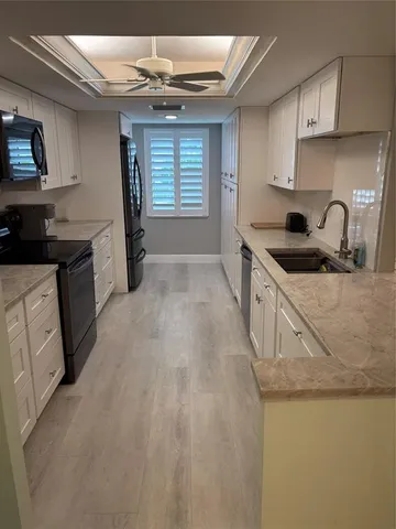 a kitchen with stainless steel appliances granite countertop a sink a stove and a refrigerator