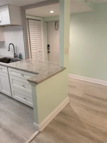 a kitchen with granite countertop white cabinets and sink