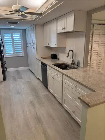 a kitchen with granite countertop a sink stainless steel appliances and cabinets