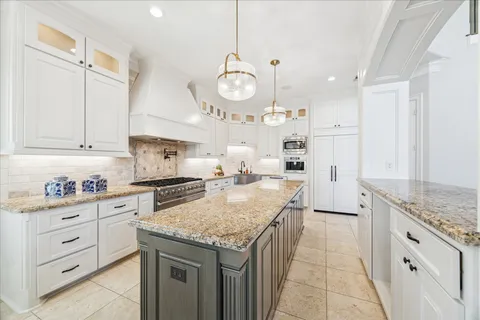 a large bathroom with a granite countertop sink a large mirror and a bathtub