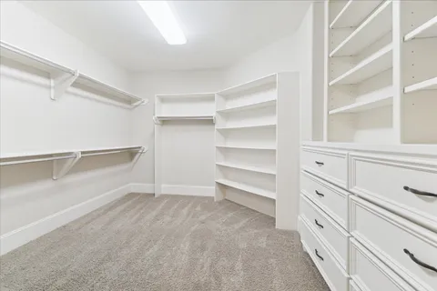 a view of walk in closet with empty racks