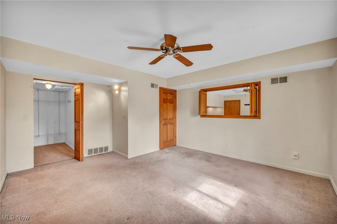 1263 Lost Nation Road, Unit 5 Willoughby, OH 44094 - Photo 19 of 26 Unfurnished bedroom with light carpet, ceiling fan, and a spacious closet