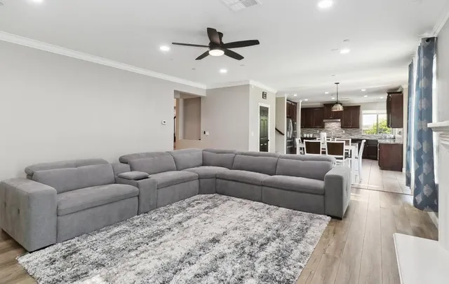 a kitchen with stainless steel appliances granite countertop a stove top oven a sink dishwasher a dining table and chairs with wooden floor