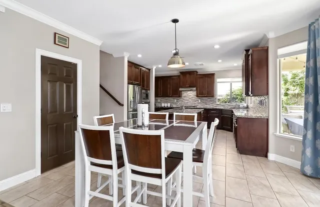 a kitchen with kitchen island granite countertop a sink stove and refrigerator