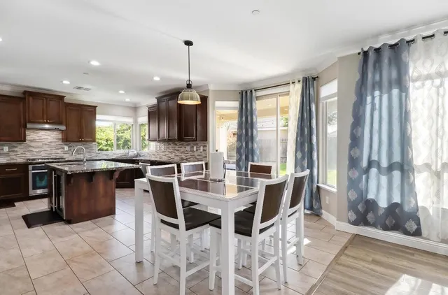 a kitchen with kitchen island granite countertop a sink stove and refrigerator