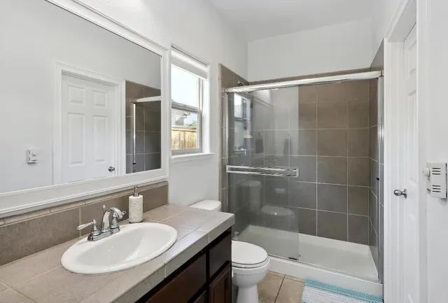 a bathroom with a sink toilet and shower